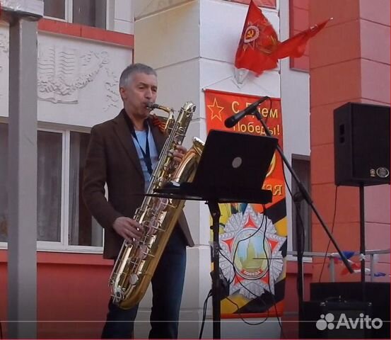Саксофонист с баритон саксофоном и аппаратурой