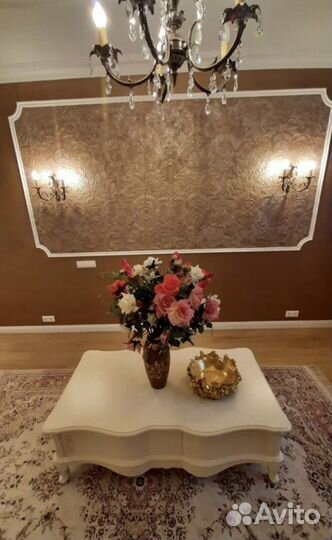 Картина в золотой раме и журнальный стол