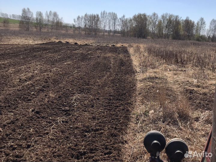 Вспашка земли трактором с почвофрезой