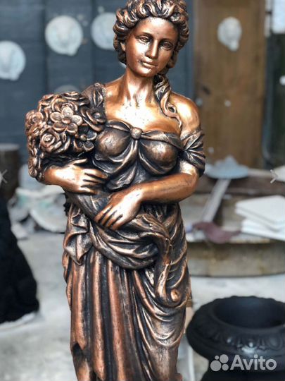 Статуя девушки из бетона с букетом