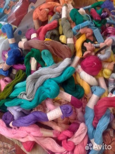 Много ниток и канвы для вышивки